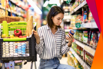 Woman kneeling in a grocery store aisle looking at products