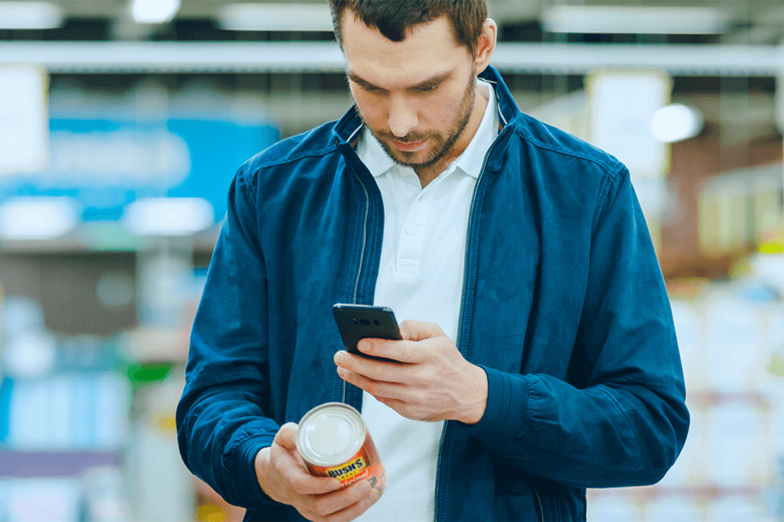 Man taking a picture of a can of beans