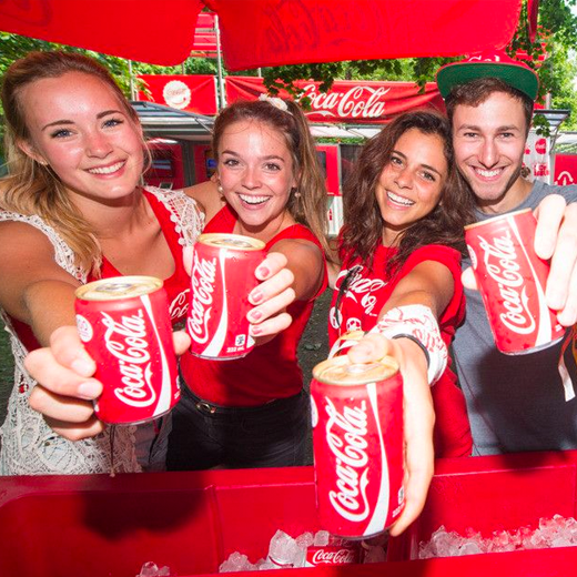People holding coca-cola cans